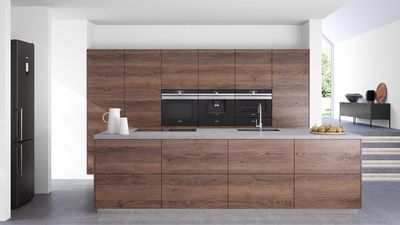 Kücheninspiration mit einer modernen dunklen Holzküche, welche mit hochwertigen Siemens Geräten ausgestattet ist。